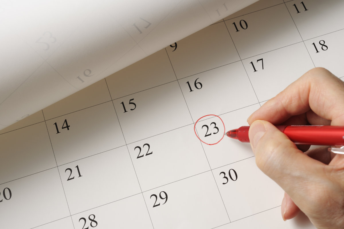 Setting a date on calendar by red pen calendrier qui represente le respect des delais